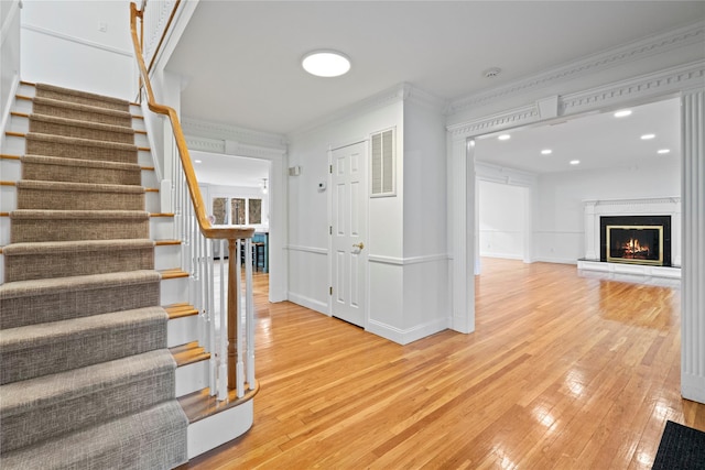 stairway with crown molding and hardwood / wood-style flooring