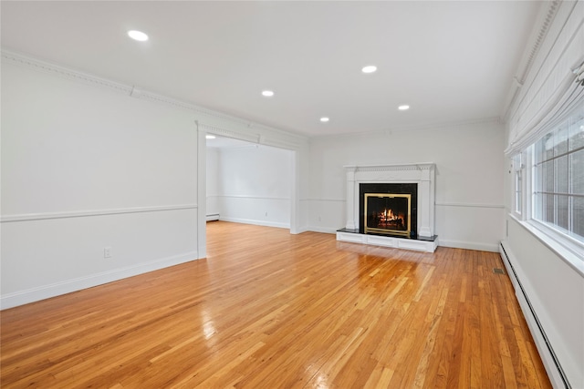 unfurnished living room featuring a high end fireplace, crown molding, light hardwood / wood-style floors, and a baseboard radiator