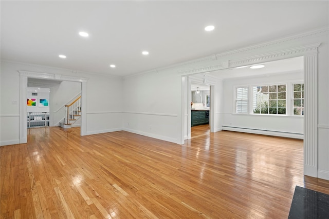 unfurnished living room with baseboard heating, light hardwood / wood-style flooring, and crown molding