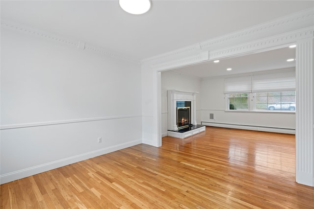 unfurnished living room with a fireplace, crown molding, light hardwood / wood-style floors, and a baseboard radiator