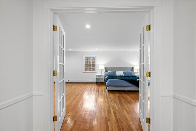 bedroom featuring a baseboard heating unit, french doors, and hardwood / wood-style floors