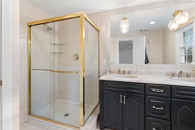 bathroom with vanity, tile walls, backsplash, and walk in shower