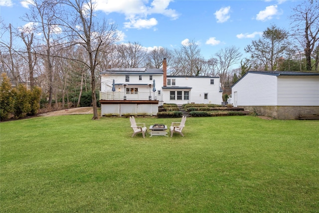 rear view of property with a lawn and a deck