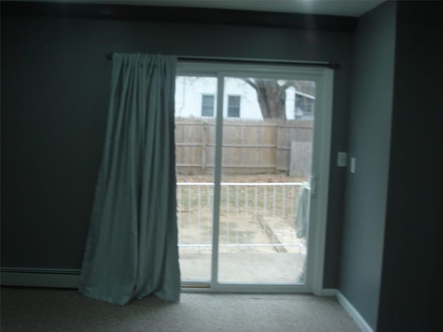 doorway to outside featuring a baseboard heating unit and carpet flooring