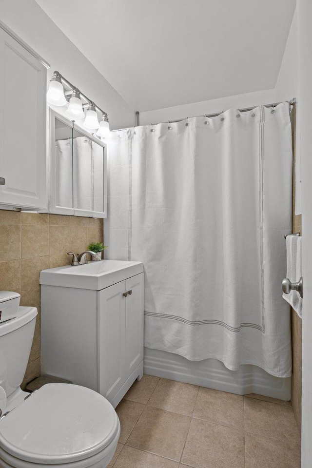 full bathroom with toilet, shower / tub combo, tile patterned floors, vanity, and backsplash