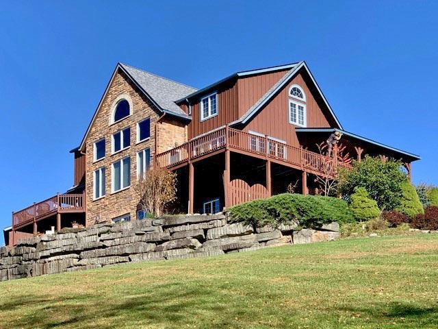 rear view of house with a wooden deck and a yard