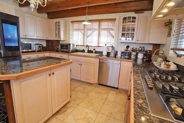 kitchen featuring beamed ceiling, white cabinetry, sink, light tile patterned floors, and stainless steel appliances