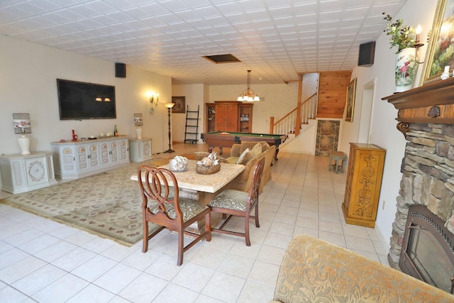 tiled dining room featuring pool table and a fireplace