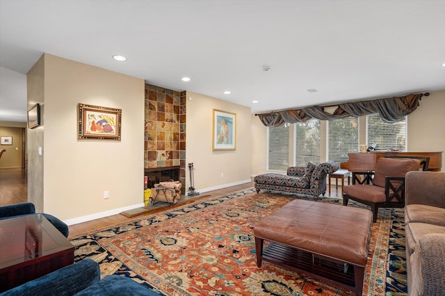 living room with wood-type flooring and a tile fireplace