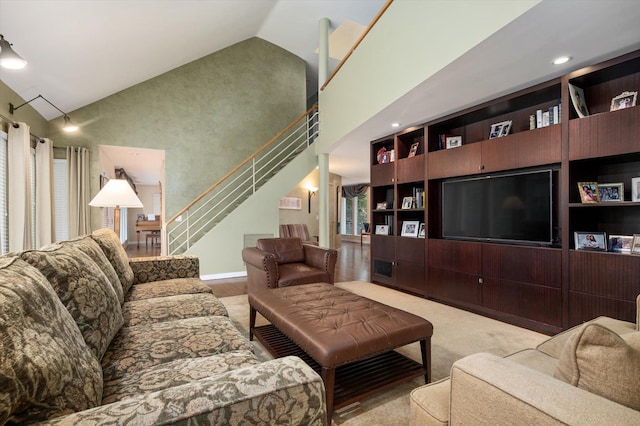 living room featuring built in shelves, light colored carpet, and high vaulted ceiling