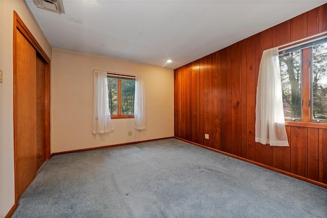 carpeted empty room with wooden walls