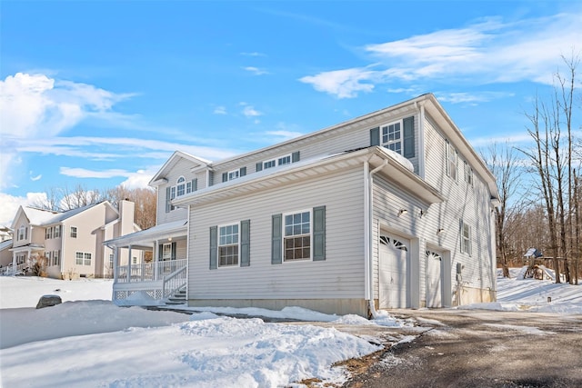 view of property with a porch and a garage