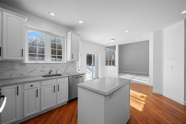 kitchen with a kitchen island, tasteful backsplash, sink, white cabinets, and stainless steel dishwasher