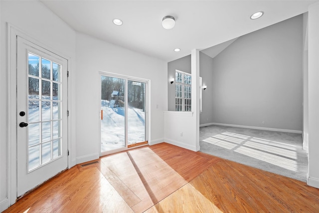 entryway with vaulted ceiling and light hardwood / wood-style flooring