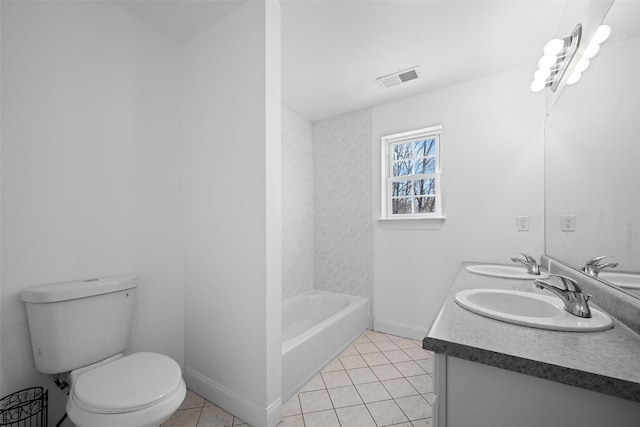 bathroom featuring tile patterned flooring, vanity, a tub, and toilet