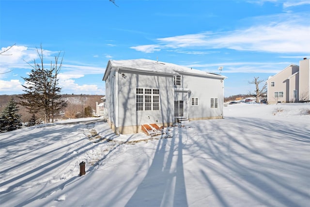 view of snow covered rear of property