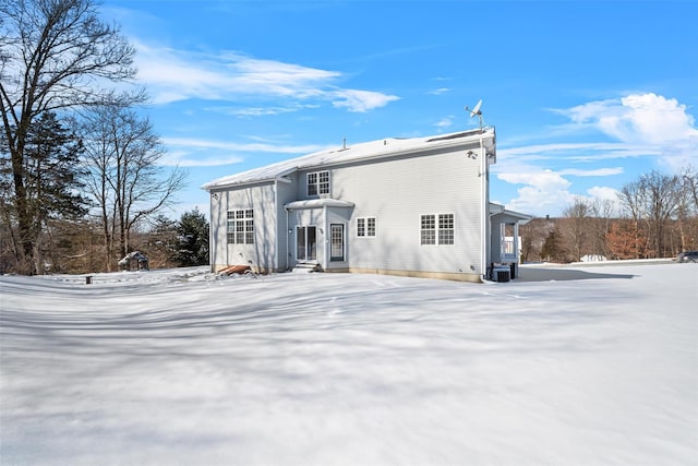 view of snow covered back of property