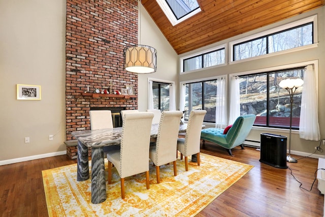 dining room featuring wood ceiling, wood-type flooring, a skylight, high vaulted ceiling, and a baseboard radiator