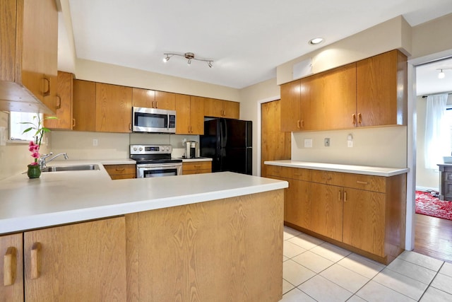 kitchen with sink, stainless steel appliances, kitchen peninsula, and light tile patterned flooring