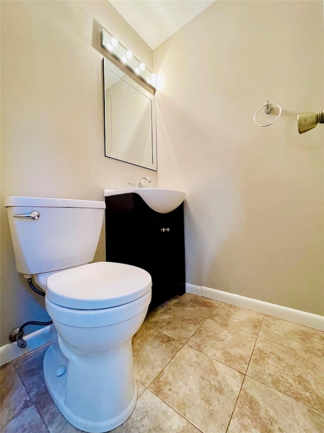 bathroom featuring tile patterned flooring, vanity, and toilet