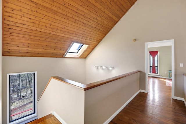 hallway featuring a skylight, wood-type flooring, wooden ceiling, and high vaulted ceiling