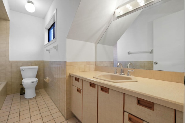 bathroom with lofted ceiling, tile walls, tile patterned flooring, vanity, and toilet