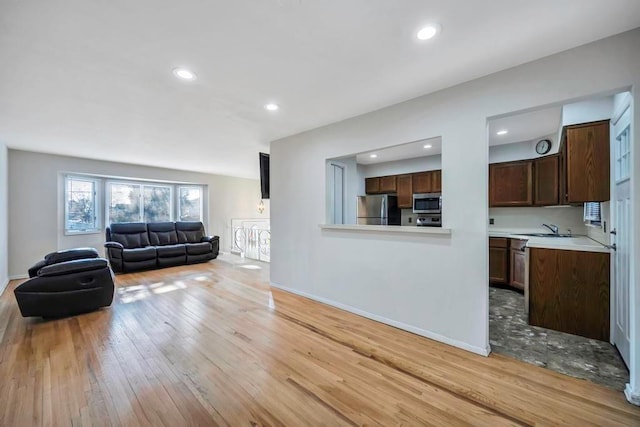 living room with sink and light hardwood / wood-style floors