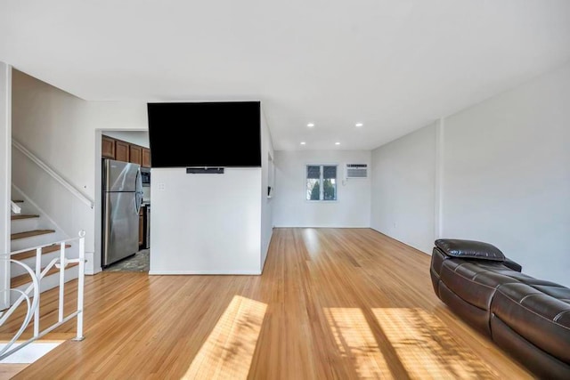 living room featuring a wall mounted AC and light wood-type flooring