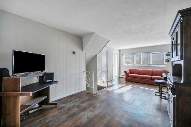 living room with a baseboard heating unit and dark wood-type flooring