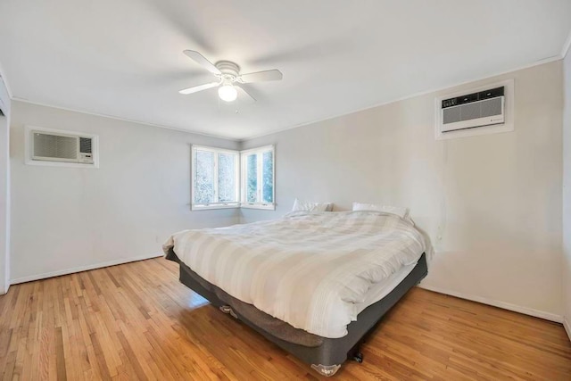 bedroom with an AC wall unit, ceiling fan, and light wood-type flooring