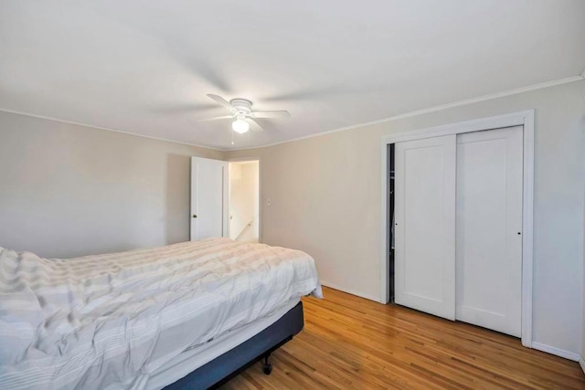 bedroom featuring ceiling fan, wood-type flooring, and a closet