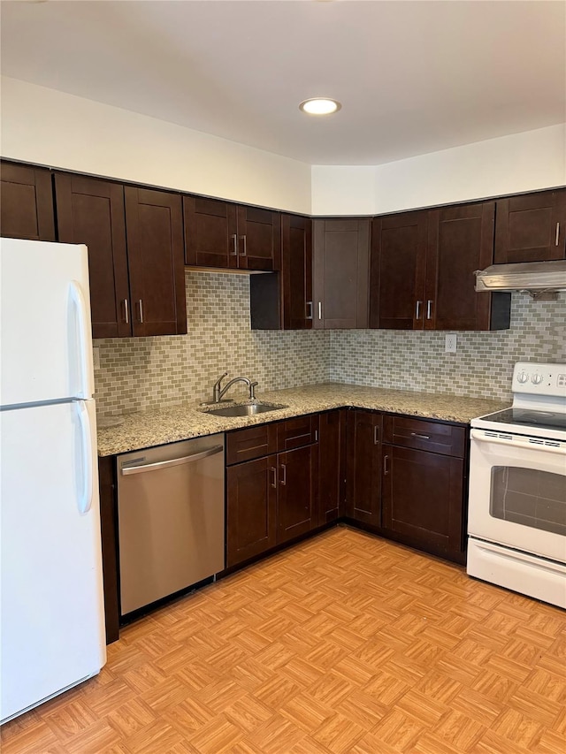 kitchen featuring sink, tasteful backsplash, dark brown cabinetry, and white appliances