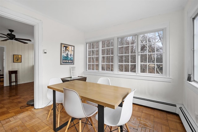 dining area with baseboard heating, ceiling fan, and parquet flooring