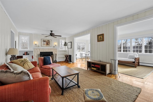 living room featuring a wealth of natural light, parquet floors, and a stone fireplace