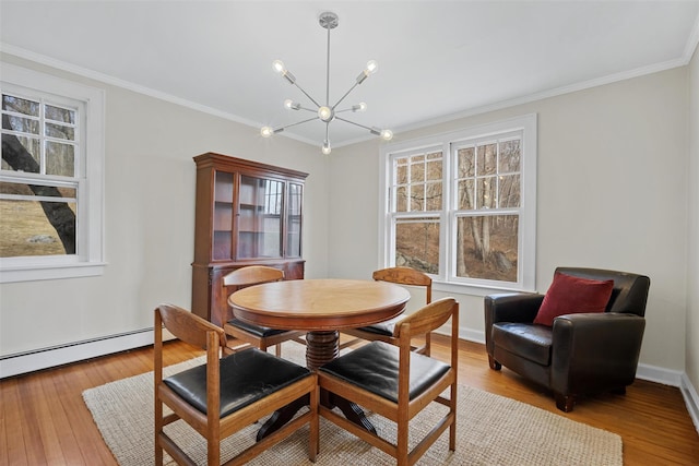 dining space with light wood-type flooring, a notable chandelier, crown molding, and a baseboard radiator