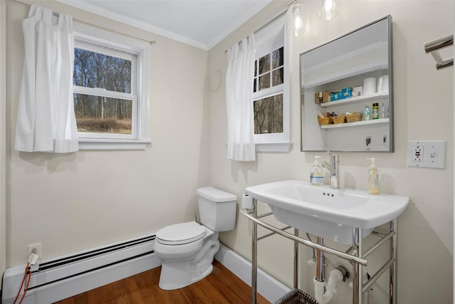 bathroom featuring wood-type flooring, a baseboard heating unit, crown molding, and toilet