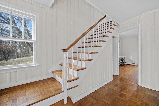 stairs with a baseboard radiator, ornamental molding, and parquet floors