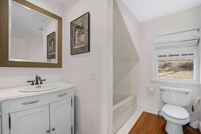 bathroom with vanity, hardwood / wood-style flooring, a washtub, and toilet