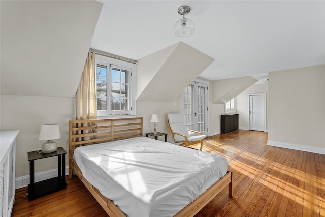 bedroom featuring french doors, lofted ceiling, and wood-type flooring