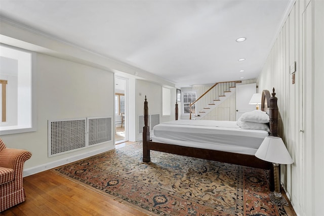 bedroom with wood-type flooring and ornamental molding