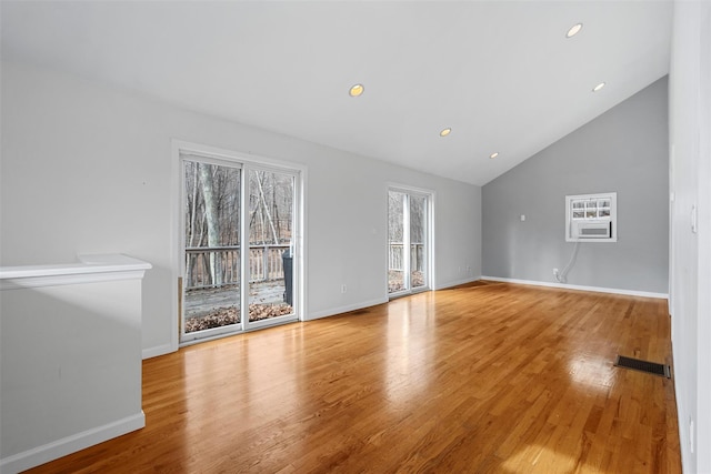 unfurnished living room with lofted ceiling and light wood-type flooring