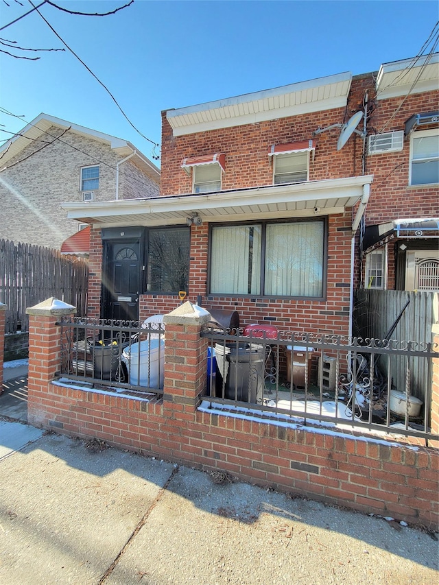 view of front of property featuring fence and brick siding