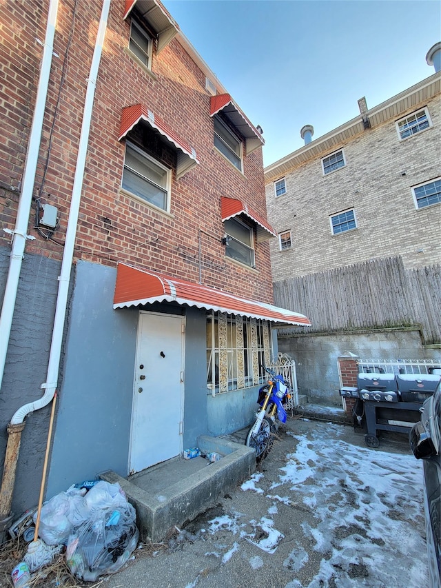 back of house with fence and brick siding