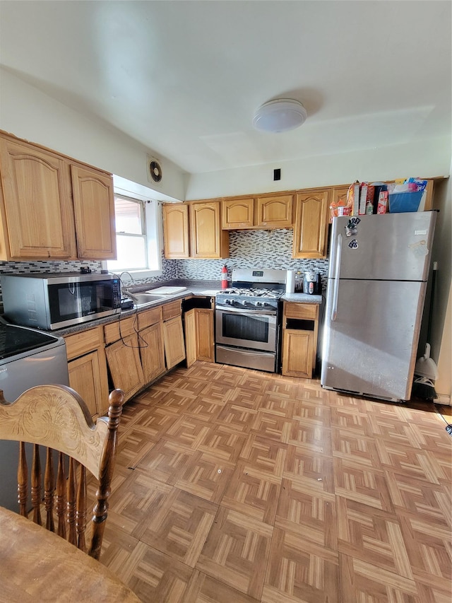 kitchen featuring light brown cabinets, a sink, dark countertops, stainless steel appliances, and decorative backsplash