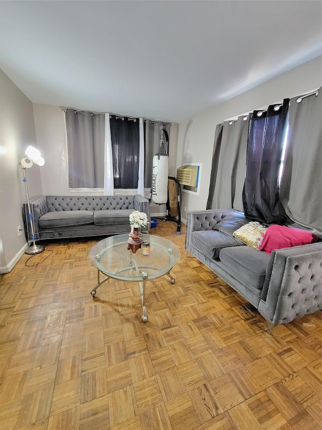 living room with an AC wall unit and baseboards