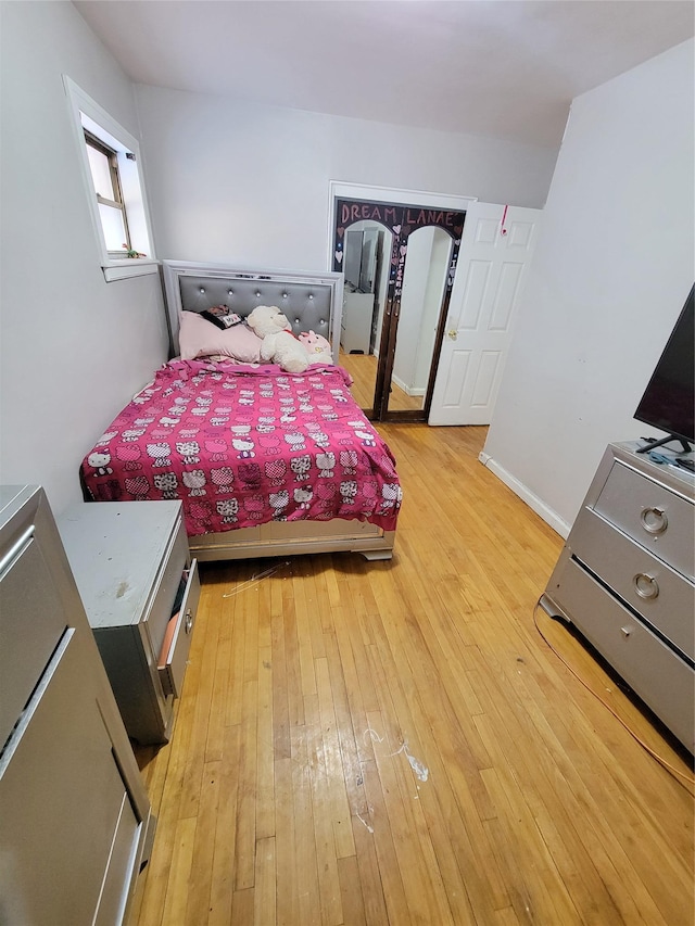 bedroom with light wood-type flooring and baseboards