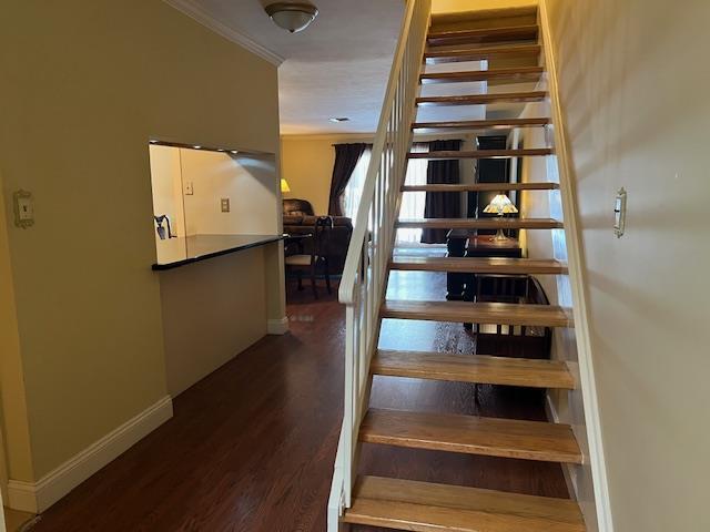 staircase with ornamental molding and wood-type flooring