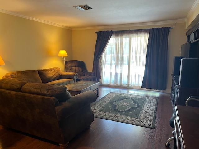 living room with dark hardwood / wood-style floors and ornamental molding