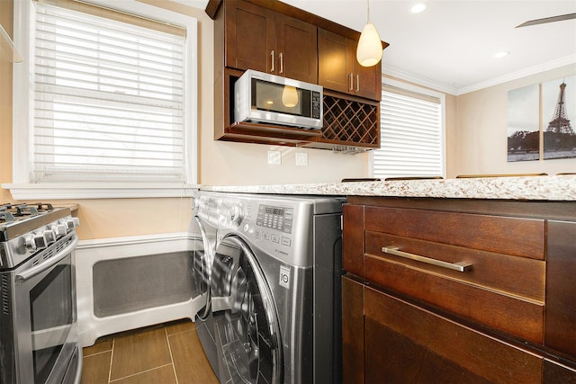 laundry room with washer / clothes dryer, crown molding, and dark tile patterned flooring