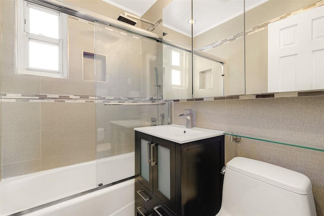 full bathroom featuring toilet, ornamental molding, vanity, enclosed tub / shower combo, and decorative backsplash